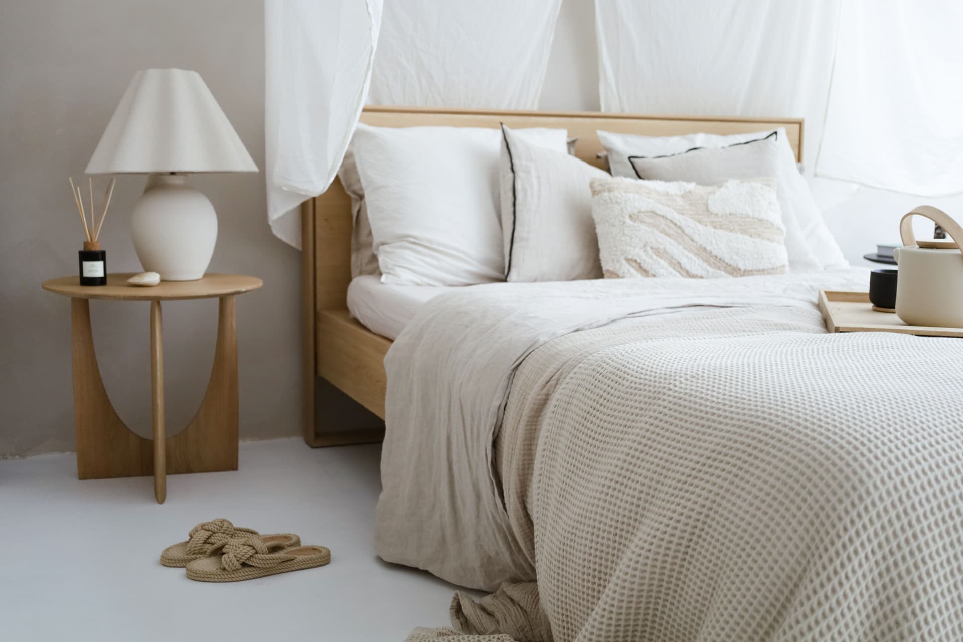 A calm, uncluttered bedroom with a made bed and natural light