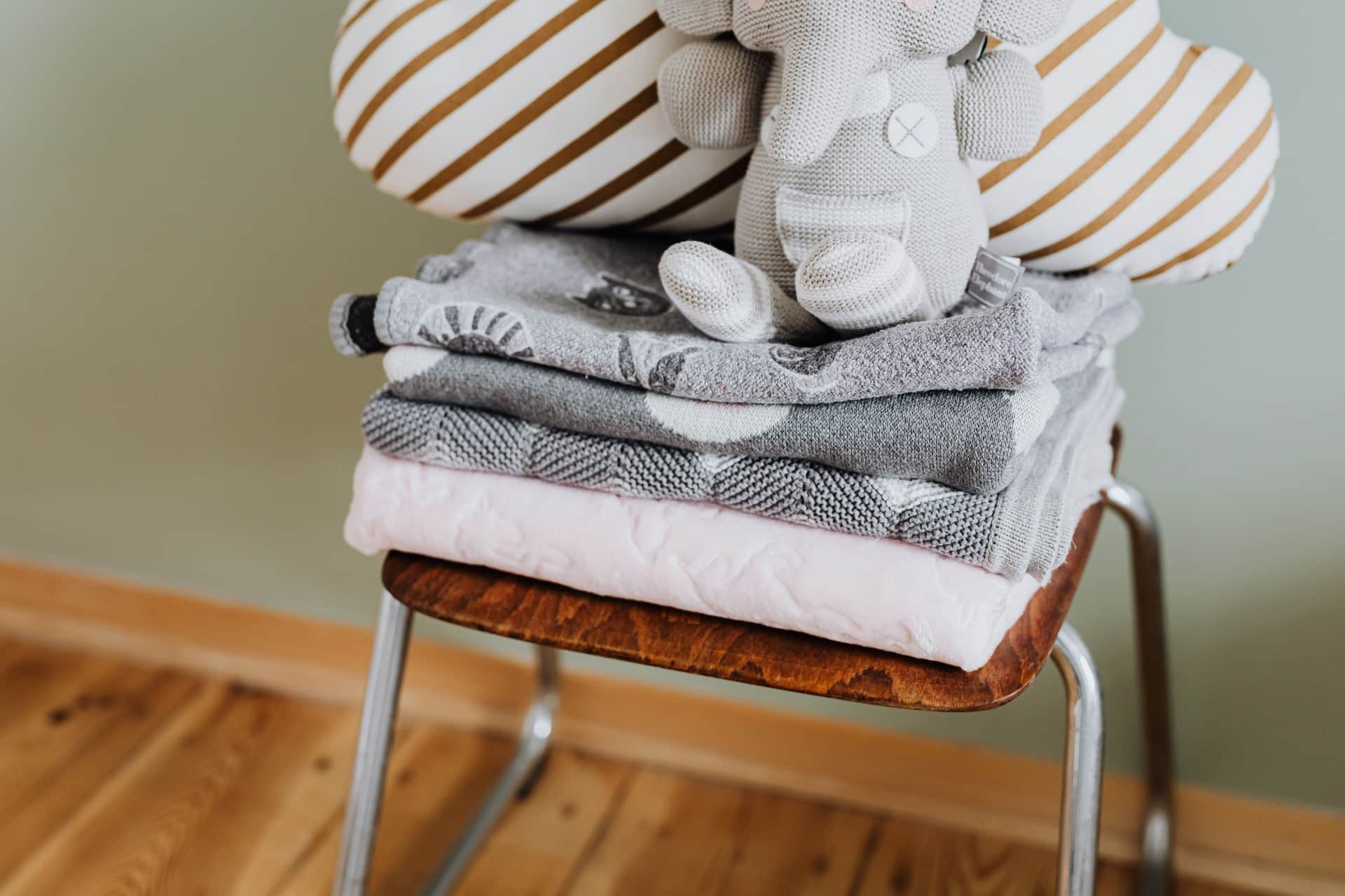 Soft layered bedding and a mattress topper on a wooden bed frame